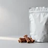 Dog treat packaging: a stand-up pouch of dog treats with a few meat treats beside it