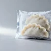 Concept visual of a frozen dumpling packaging pouch in cold-chain conditions with frost on the film