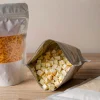 Matte stand-up pouches filled with shredded cheddar and cubed cheese snacks on a light wooden table