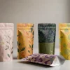 Row of four custom printed stand-up pouches with different seasonal designs on a clean studio table