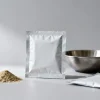 Concept visual of unprinted seasoning powder sachets and a bowl of mixed seasoning, illustrating seasoning powder packaging and seal integrity